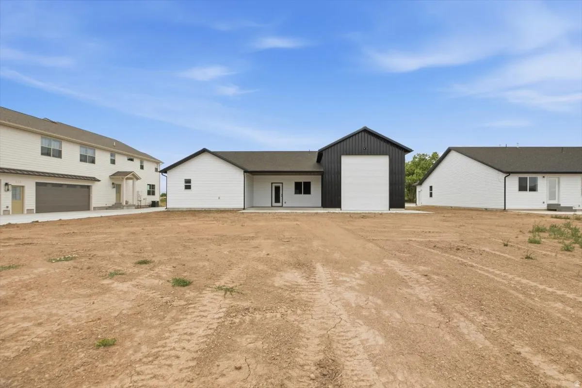 Expansive backyard space with a barn-style detached garage featuring a large white overhead door