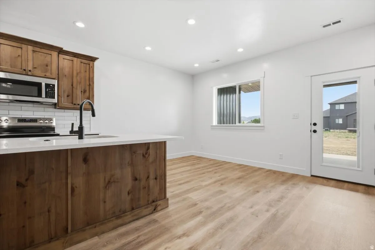 Open-concept living space featuring wood-finish flooring and recessed lighting