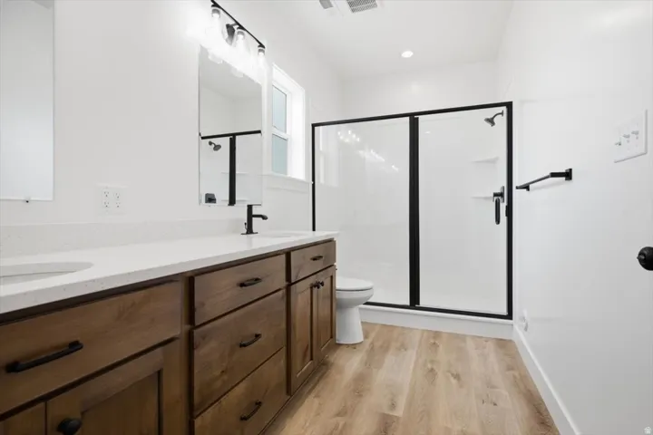 Spacious bathroom featuring a double vanity with wood cabinetry, white countertops, and dual undermount sinks