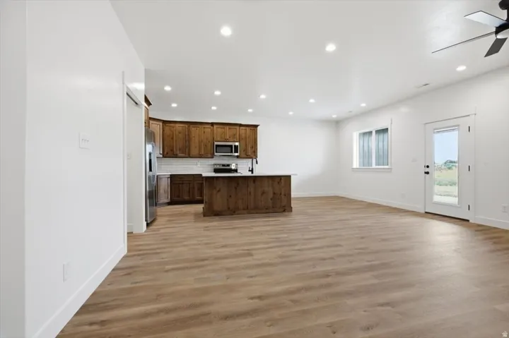 Open-concept living space featuring wood-finish flooring, recessed lighting, and a modern kitchen