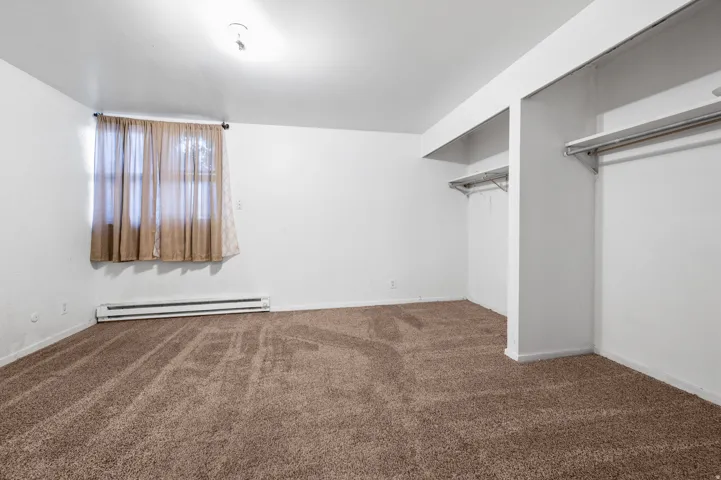 Spacious room featuring neutral-toned carpeting and bright white walls