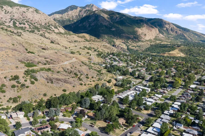 Aerial perspective showcasing a residential area nestled at the base of extensive mountains