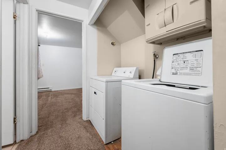 Dedicated laundry area featuring a top-loading washing machine and a separate dryer unit