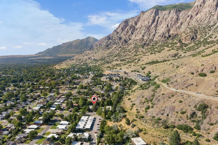 Aerial perspective showcasing a residential area nestled at the base of a rugged mountain range