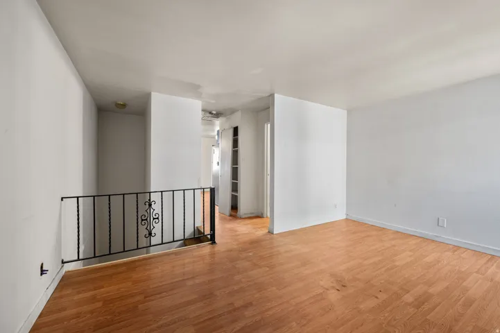Open concept living area featuring wood-finish flooring and neutral wall tones