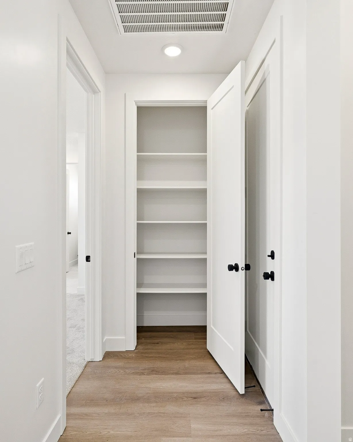 Hallway with wood-finish flooring and recessed lighting
