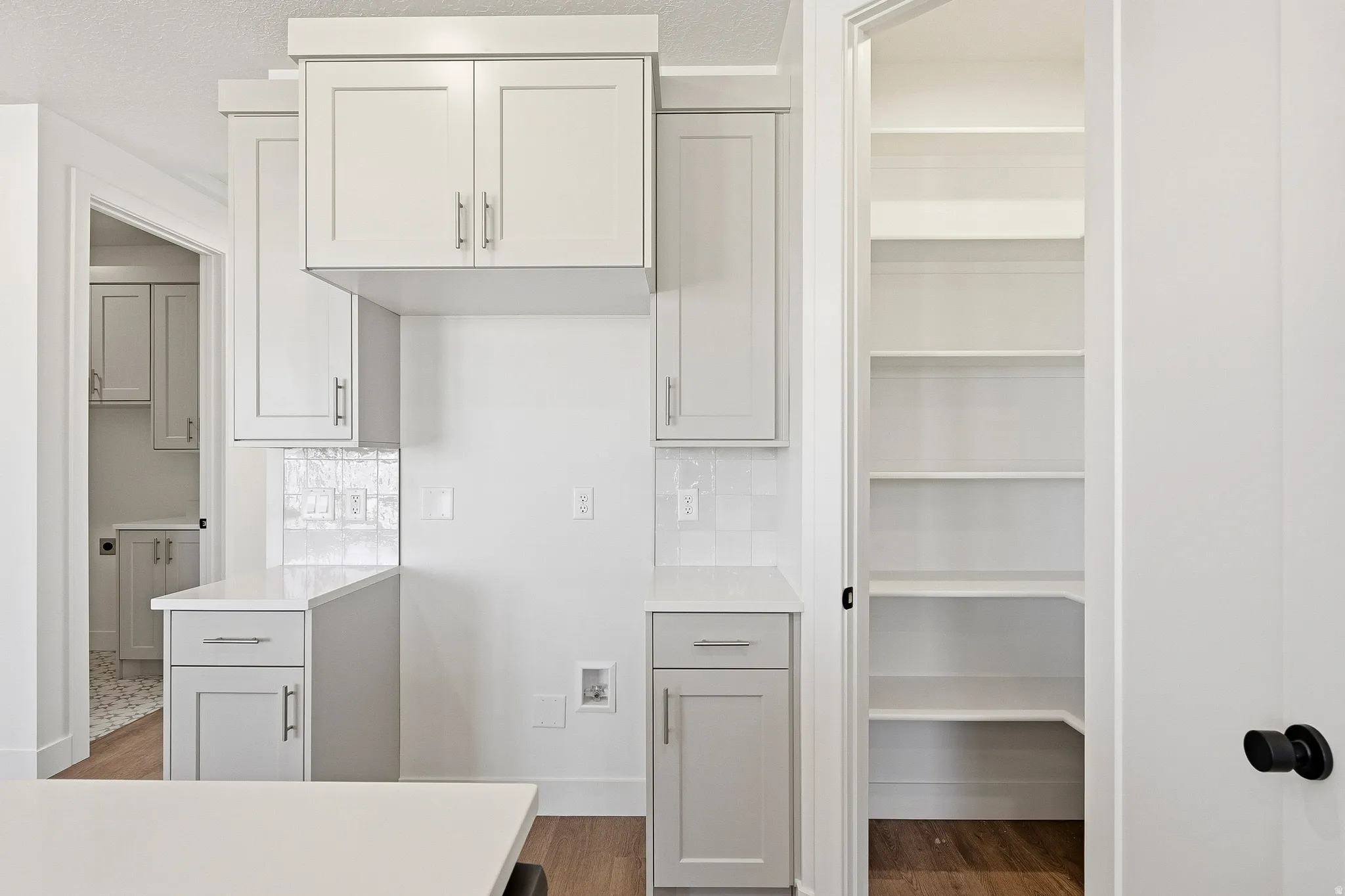 Kitchen featuring shaker-style cabinetry, white countertops, and a white subway tile backsplash
