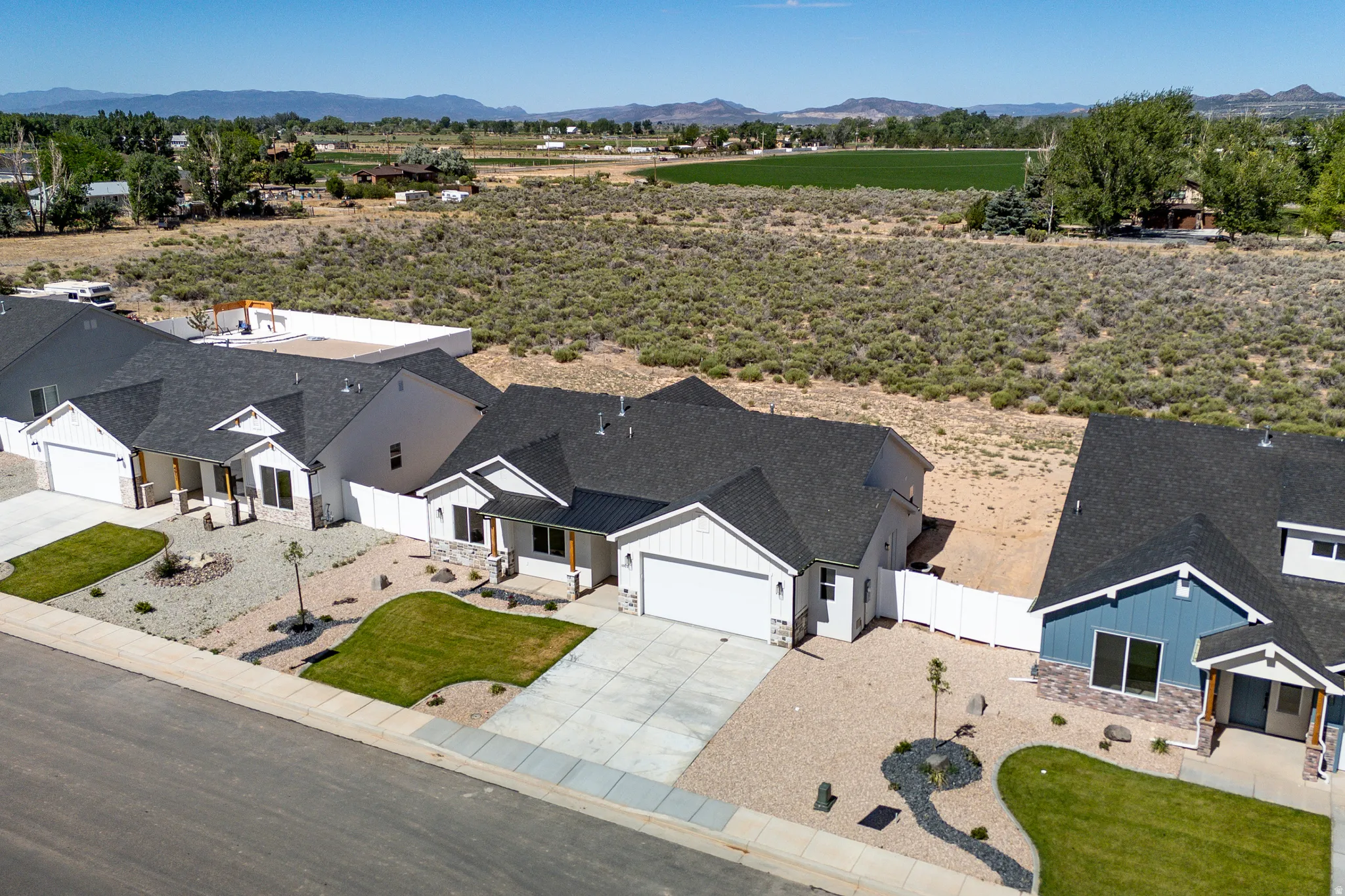Contemporary ranch-style home featuring a dark shingle roof, white siding, and an attached two-car garage