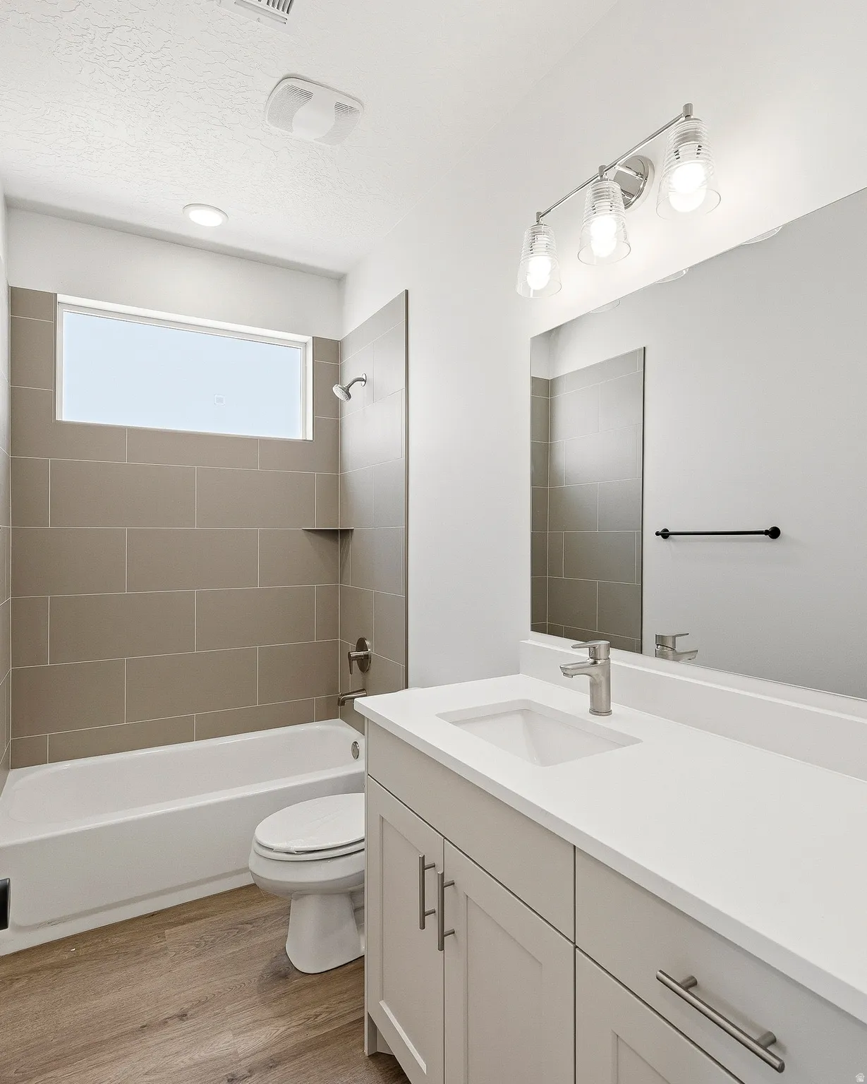 Contemporary bathroom featuring a white vanity with a single basin sink and brushed nickel hardware