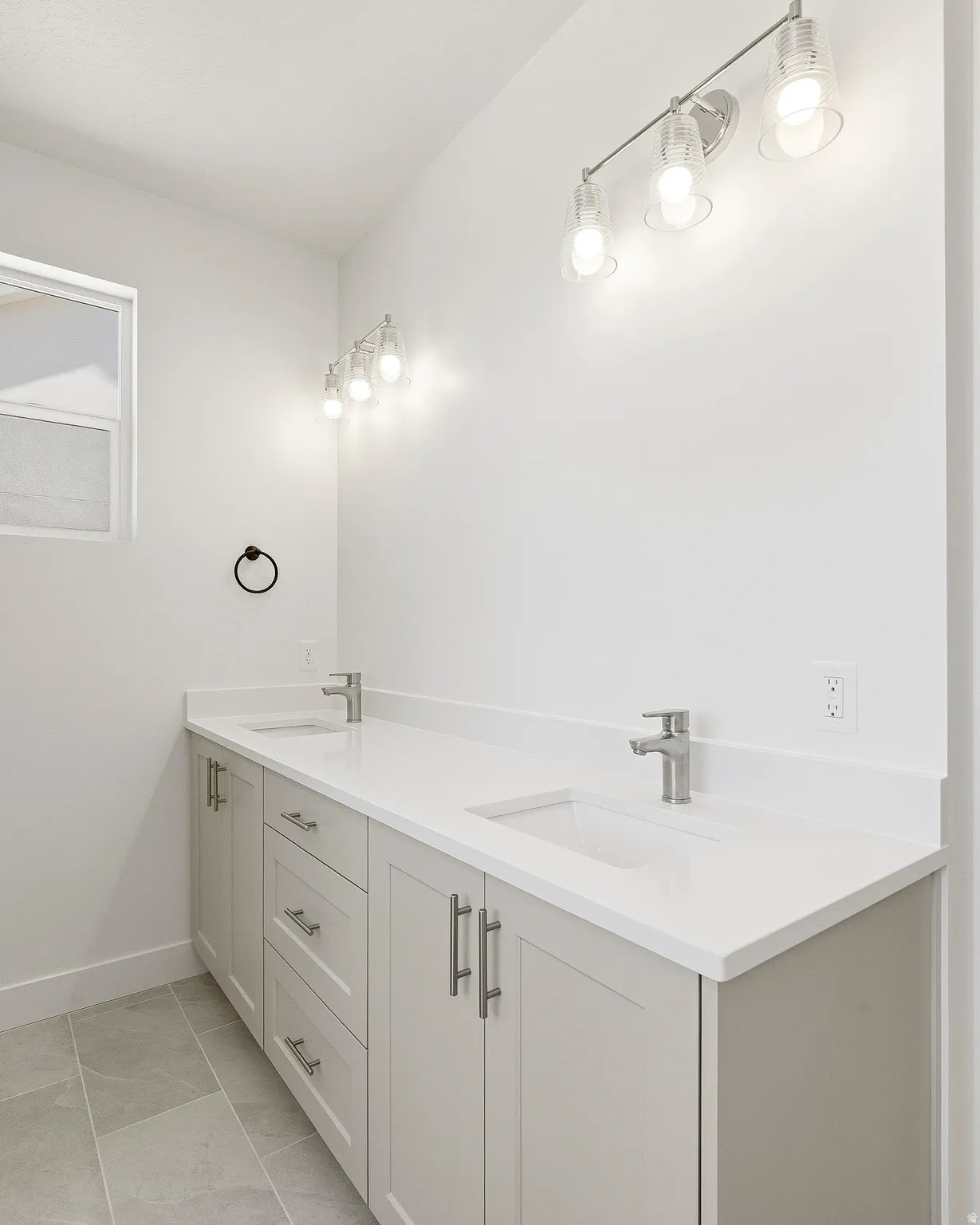 Dual vanity featuring light-toned cabinetry, brushed nickel hardware, and integrated rectangular sinks