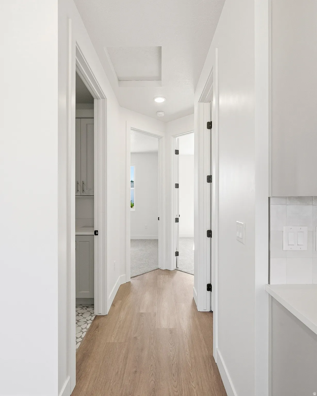 Hallway featuring wood-finish flooring, recessed lighting, and white trim