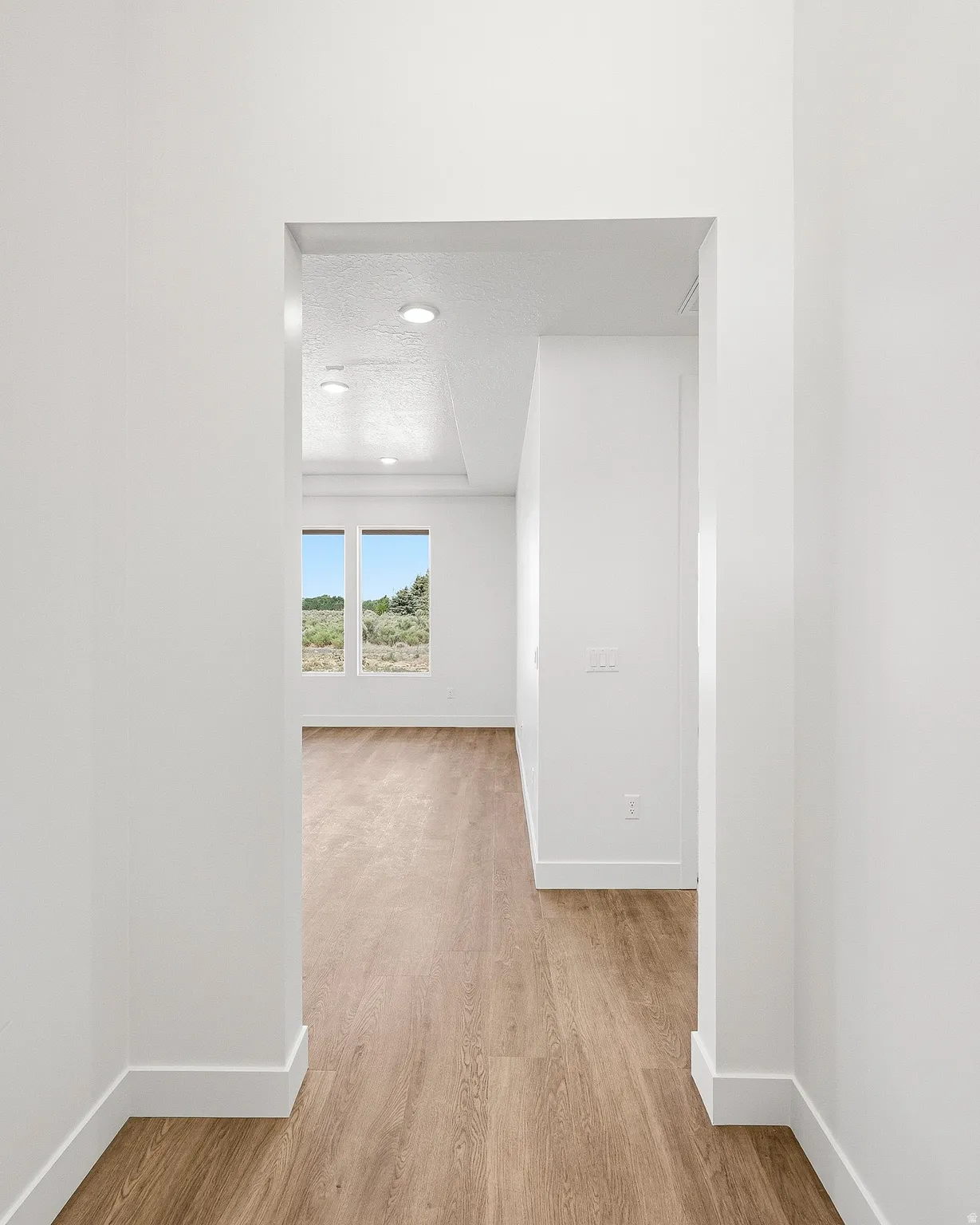 Spacious interior featuring neutral paint, wood-finish flooring, recessed lighting, and large windows