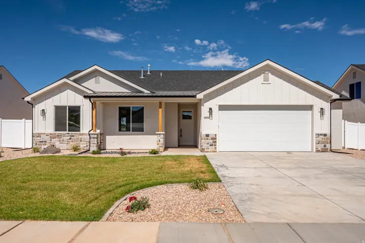 Modern ranch-style home featuring a two-car garage, stone and board-and-batten exterior accents, and a covered entry with wood-finish columns
