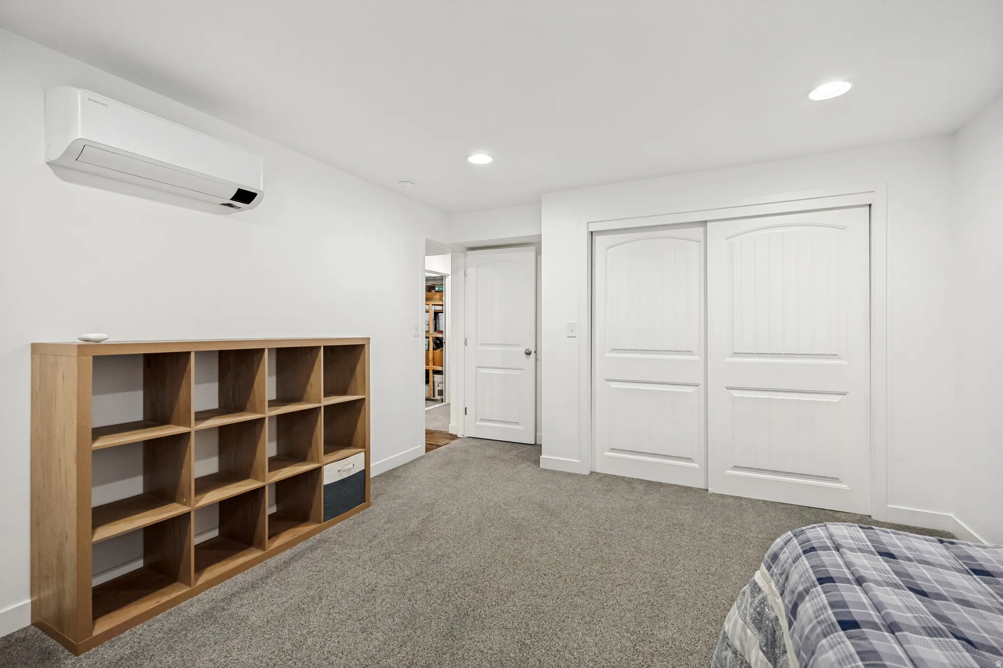 White walls and grey carpeting complement a white built-in wall-mounted climate control unit