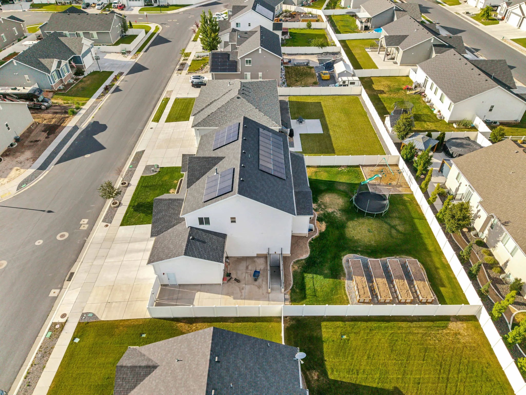 White exterior home featuring a dark shingle roof with solar panels