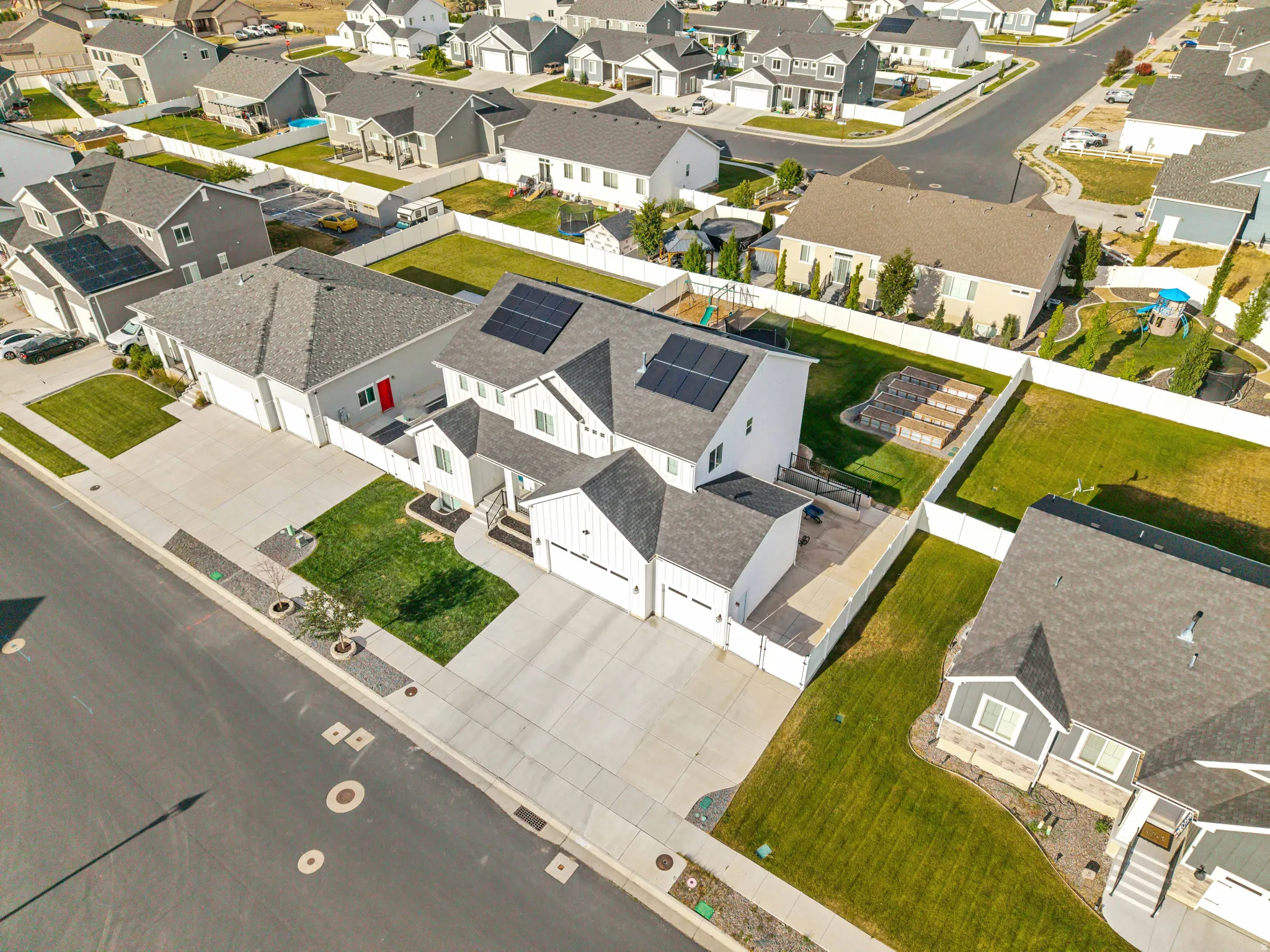 Contemporary two-story residence featuring solar panels, an attached two-car garage, and a detached two-car garage