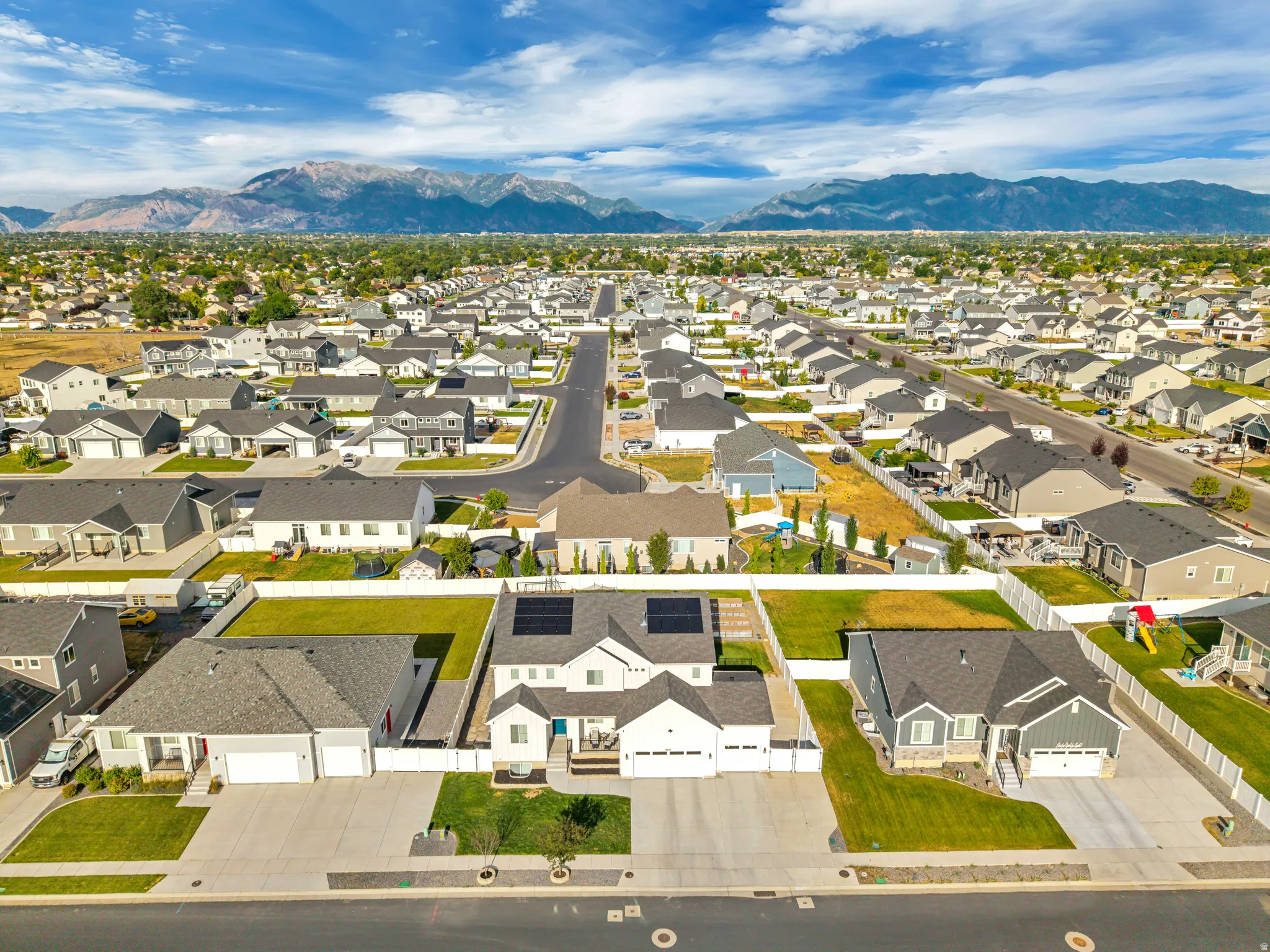 Expansive aerial perspective showcasing a residential neighborhood with distant mountains