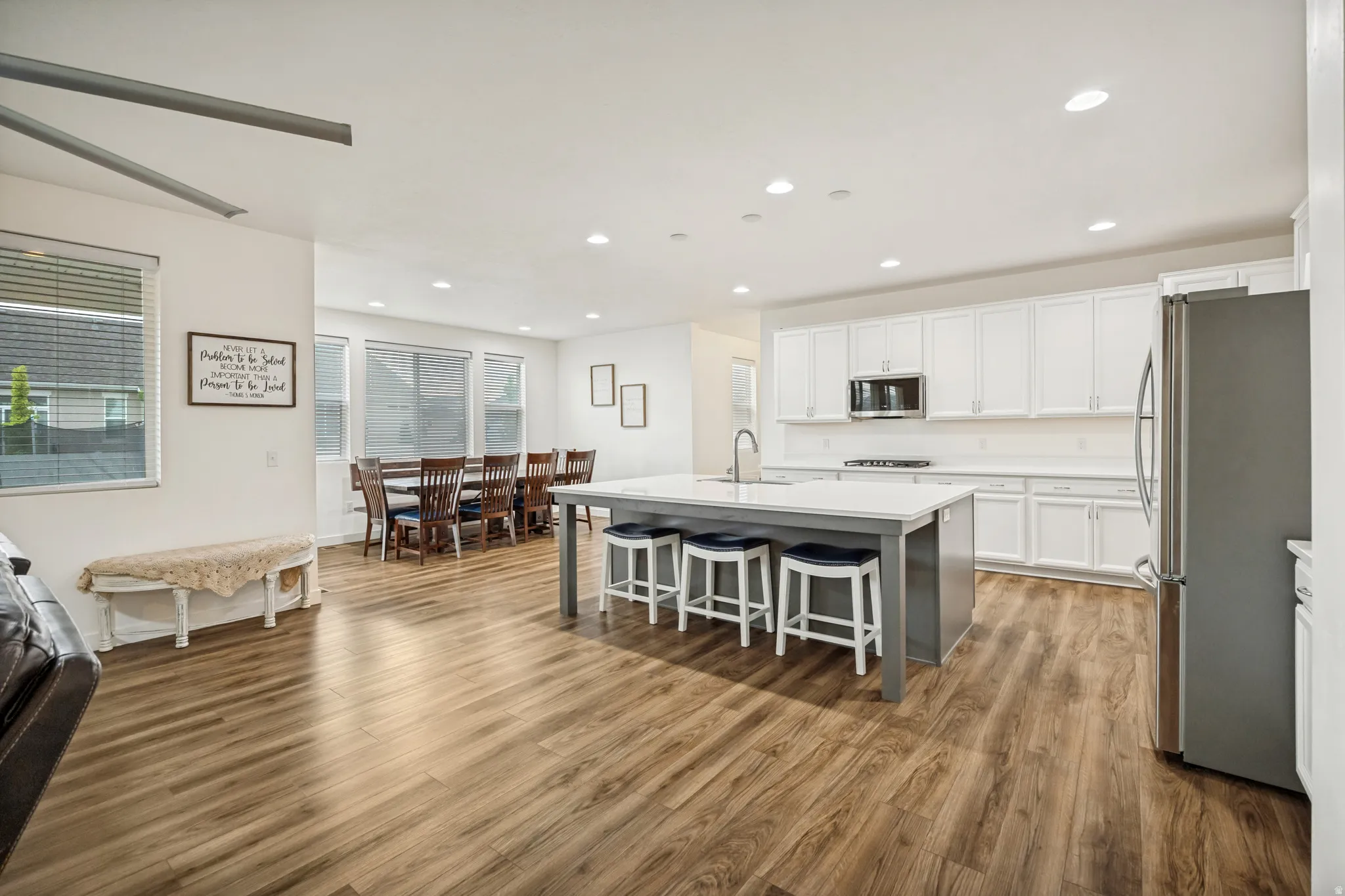 Open-concept living space featuring wood-finish flooring, recessed lighting, and large windows