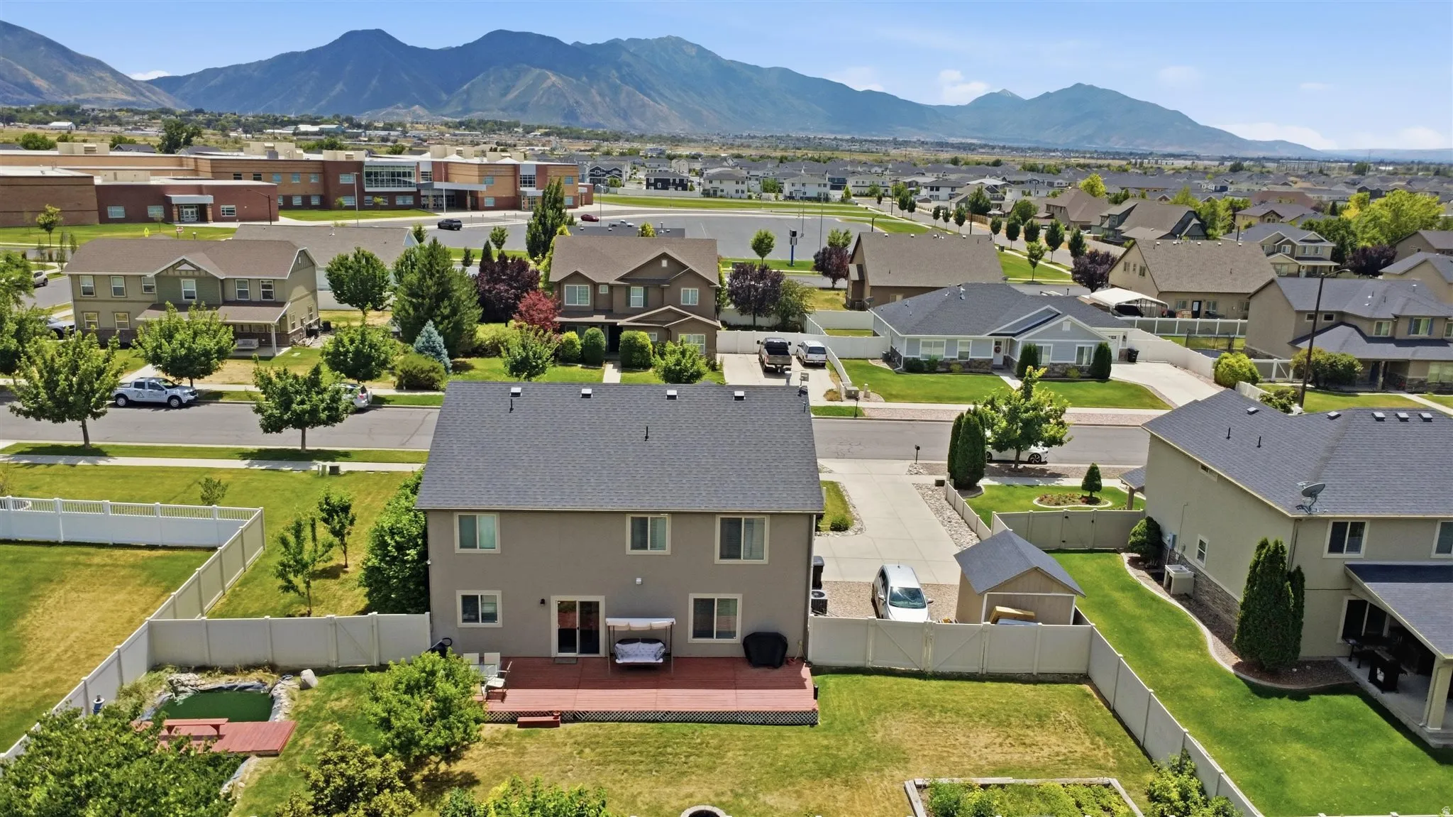Expansive property featuring a multi-level deck, fenced backyard with a pond, and a detached shed