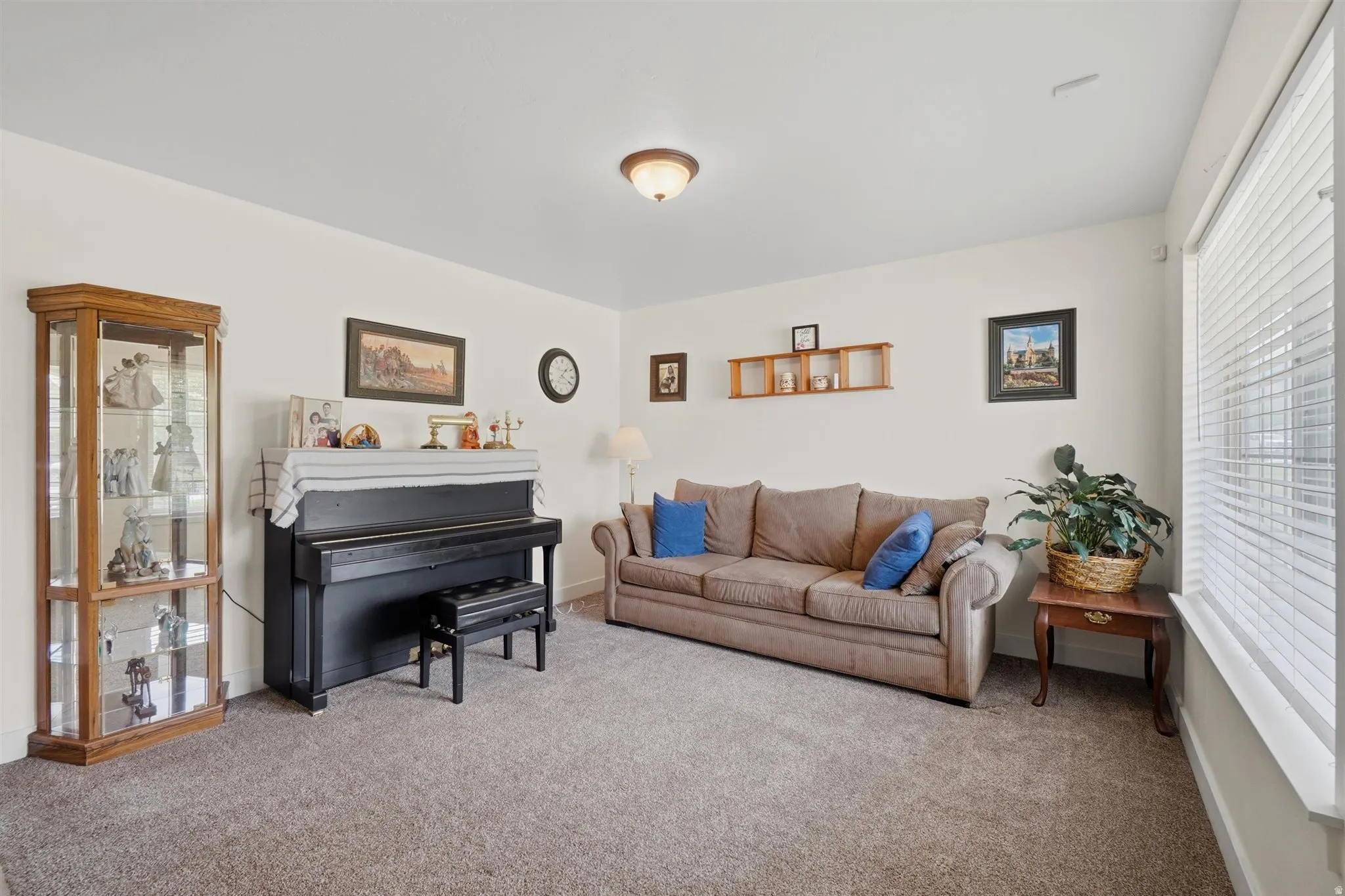 Spacious room featuring neutral carpet flooring and white walls