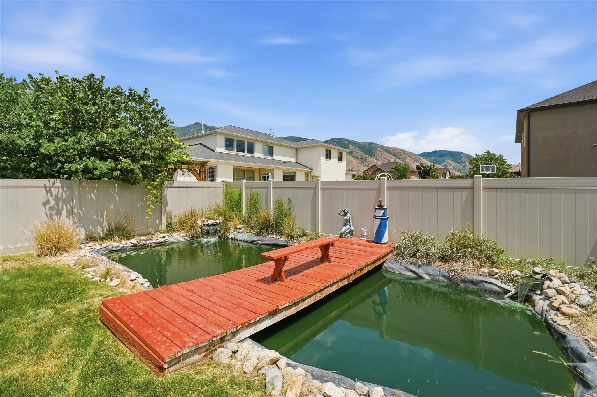 Backyard water feature with a red wooden dock and integrated seating