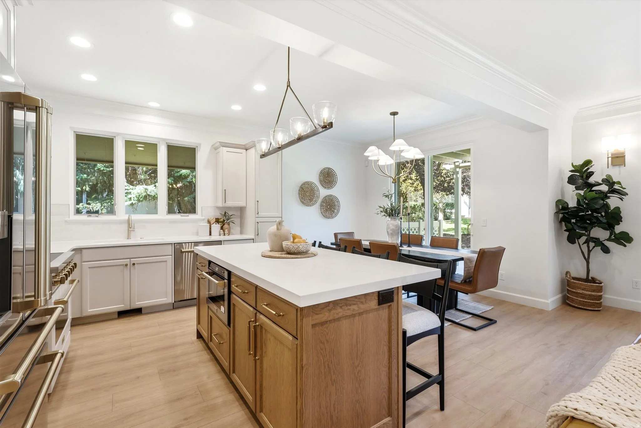 Gourmet kitchen with a large island, stainless steel appliances, light wood-finish flooring, and recessed lighting