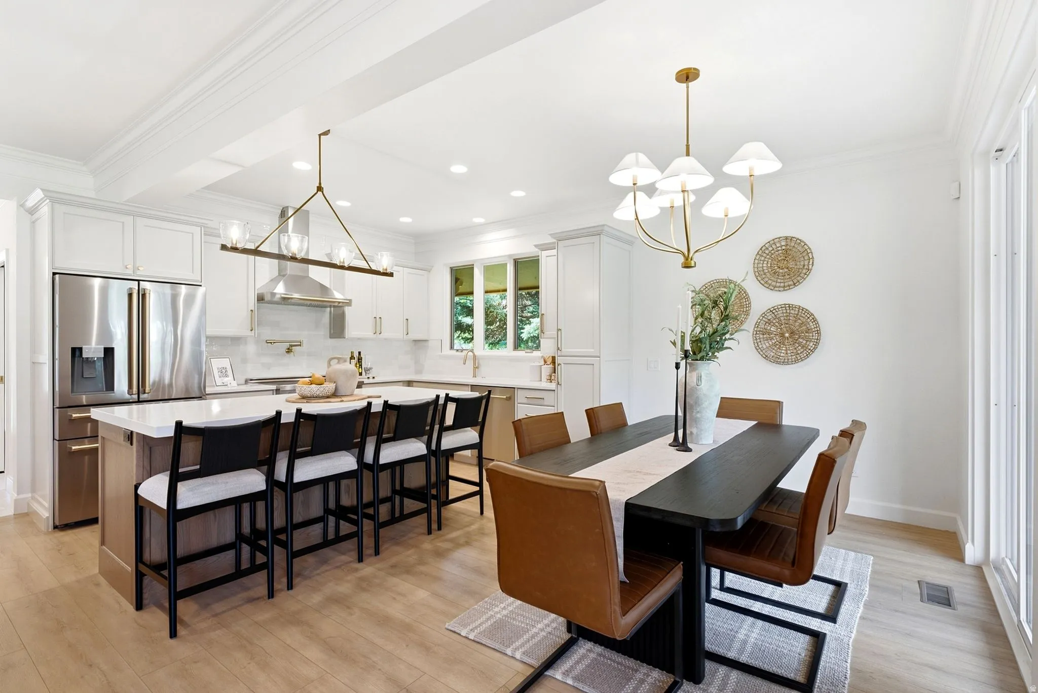 Gourmet kitchen with stainless steel appliances, central island with seating, pendant lighting, and wood-finish flooring
