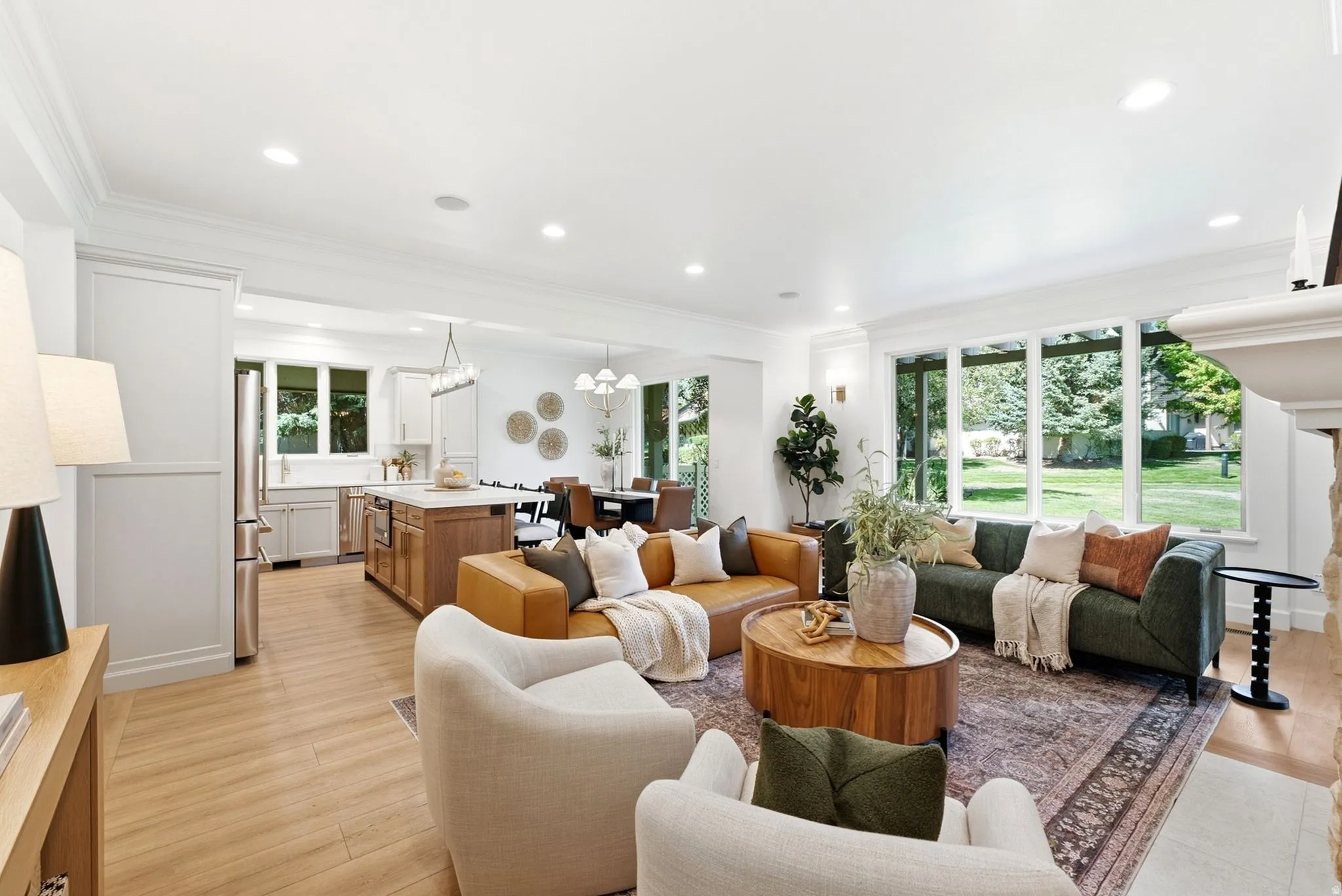 Expansive living area with wood-finish flooring, recessed lighting, and a stone-clad fireplace