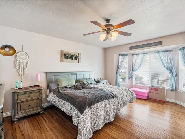 Bedroom featuring wood-finish flooring and a ceiling fan with integrated lighting