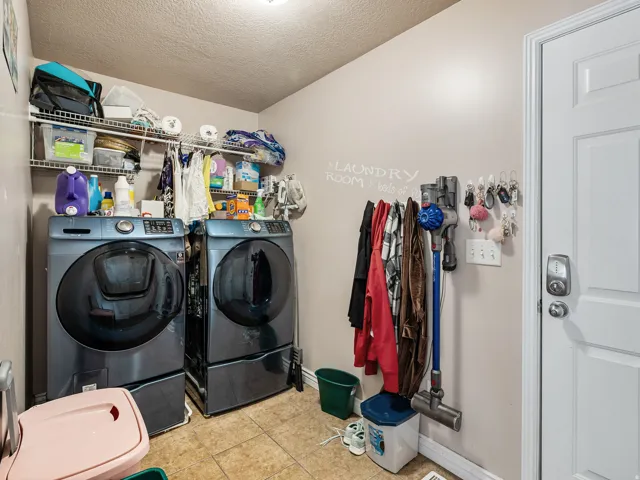 Dedicated laundry area featuring tile flooring and built-in wire shelving