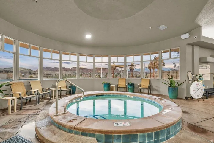 Indoor spa with curved tile surround, extensive perimeter windows, and polished concrete flooring