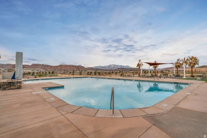 Expansive outdoor swimming pool with integrated tanning ledge and concrete decking