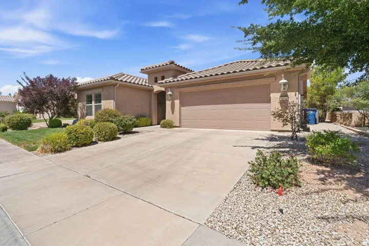 Stucco exterior residence featuring a tiled roof and an attached two-car garage