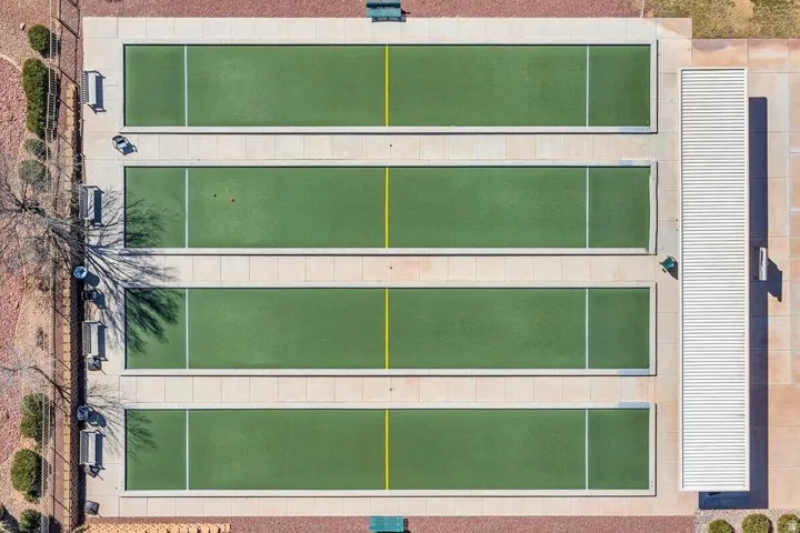 Four artificial turf bocce ball courts with concrete surrounds and white line markings