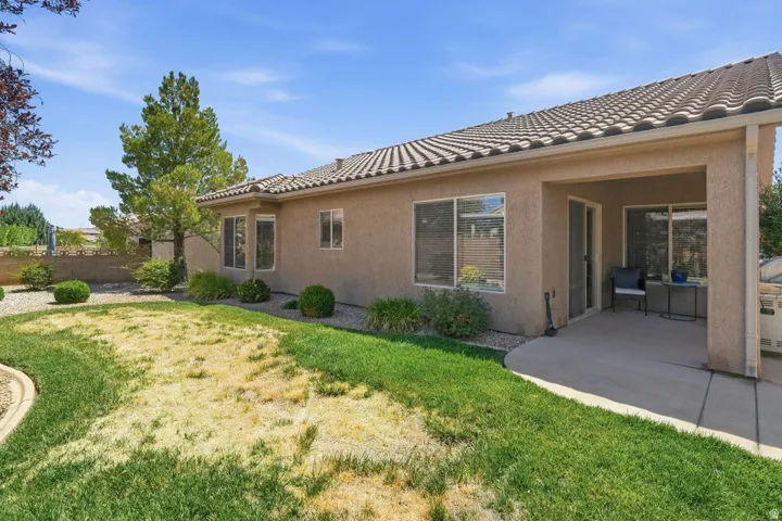 Stucco exterior featuring multiple windows and a covered patio
