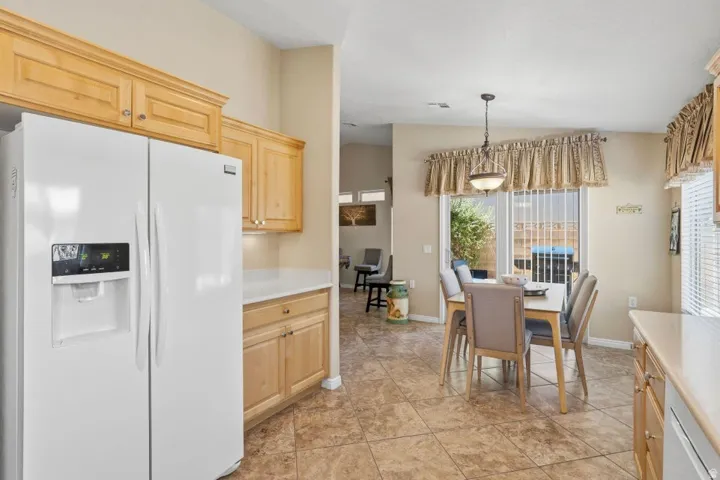 Kitchen area featuring wood cabinetry, light-toned countertops, and tile flooring