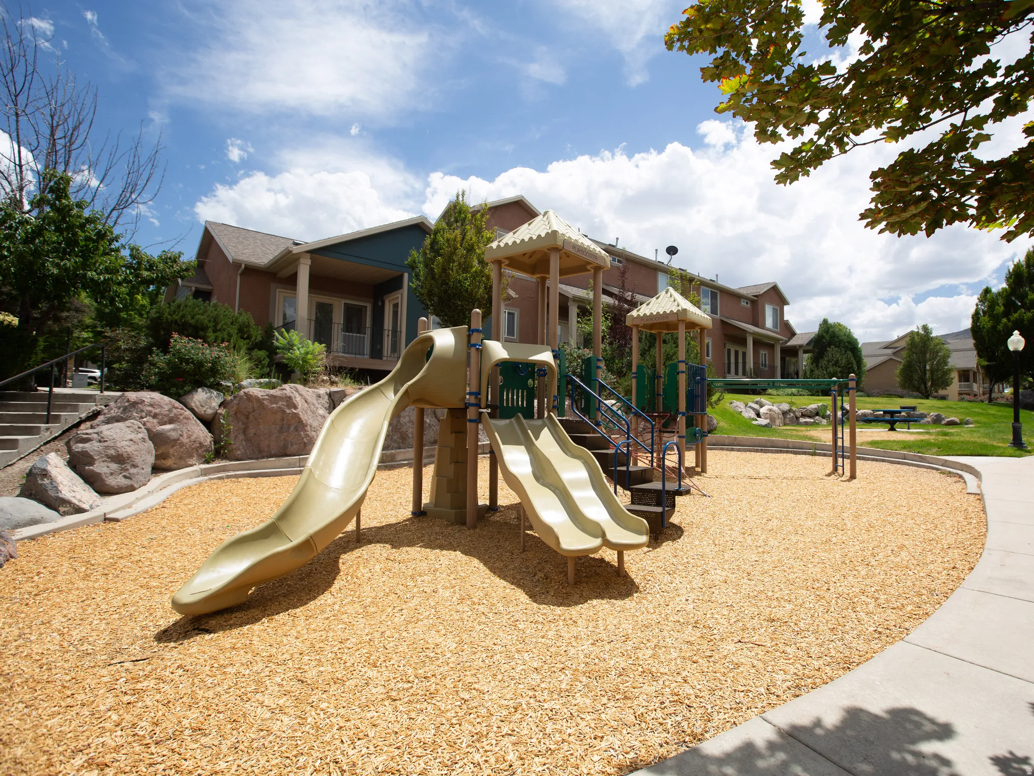 Community playground featuring a multi-level play structure with multiple slides