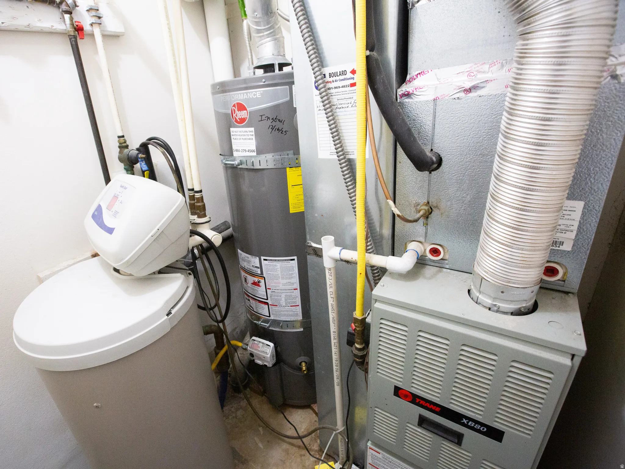 Dedicated utility area featuring a water heater, water softener system, and furnace
