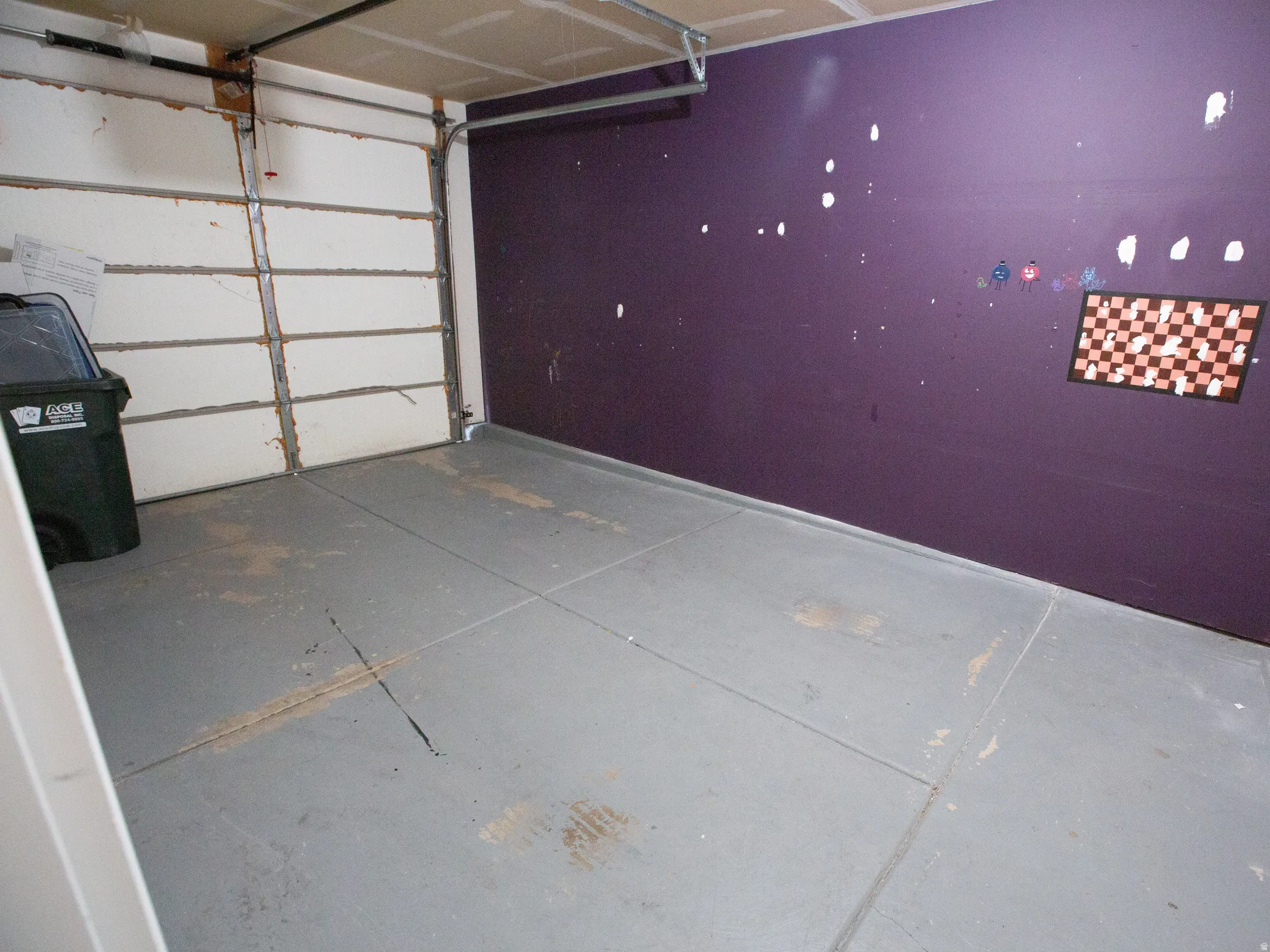 Interior garage space featuring a roll-up garage door and a painted concrete floor