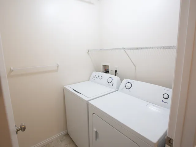 Dedicated laundry area featuring a washer and dryer, an overhead wire shelf, and a wall-mounted drying rod