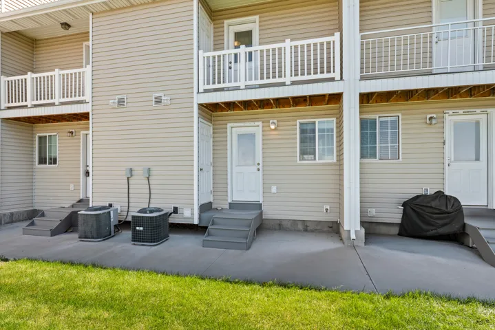 Multi-level exterior featuring tan vinyl siding and white trim