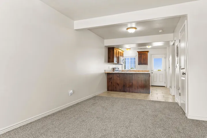 Open-concept room featuring gray carpet flooring and white baseboards