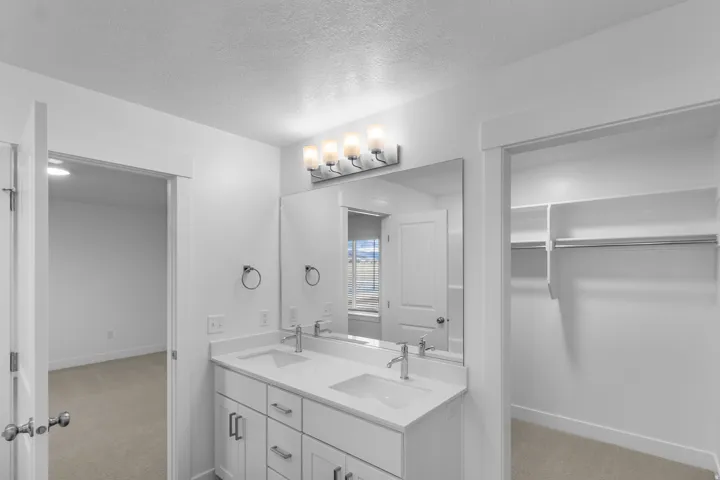 Bathroom featuring a dual vanity with white cabinetry and integrated sinks