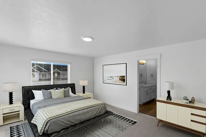 Spacious room featuring neutral carpeting, a large window with blinds, and white walls