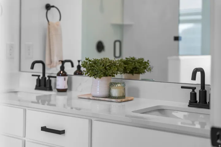 Dual sink vanity featuring white cabinetry with matte black hardware, white countertop, and matte black fixtures