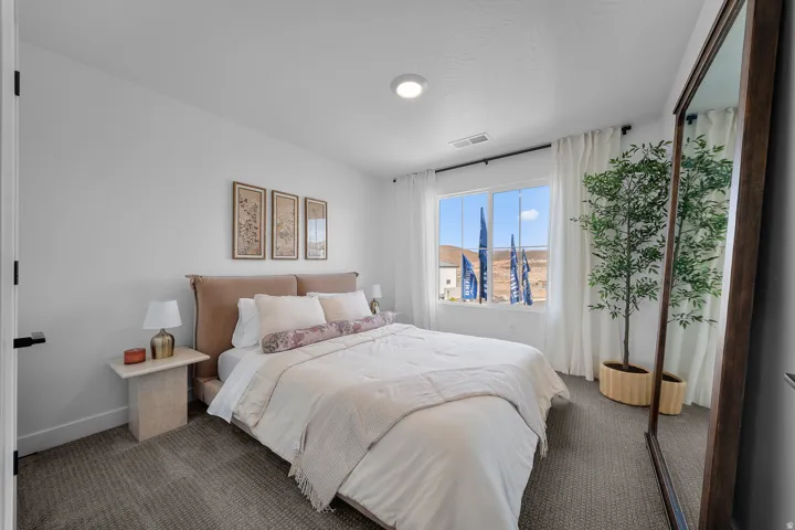 Carpeted bedroom featuring a large window, high ceilings, and a flush-mount ceiling light