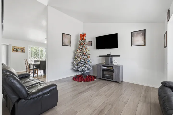 Spacious living area featuring light wood-finish flooring and white baseboards