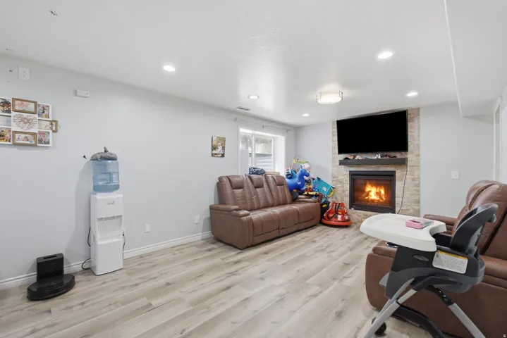 Living area featuring a floor-to-ceiling stacked stone fireplace with a wood mantle