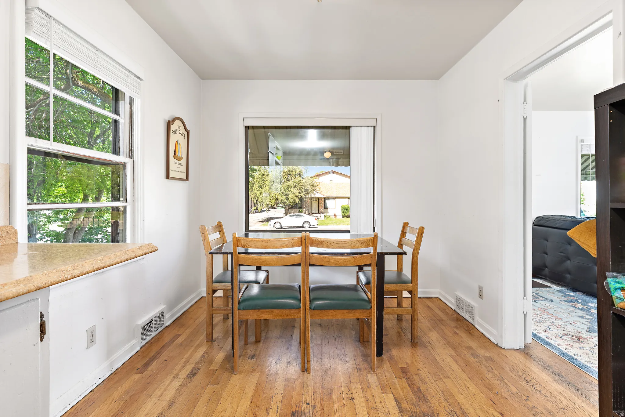 Dining area featuring wood-finish flooring, white walls, and prominent windows