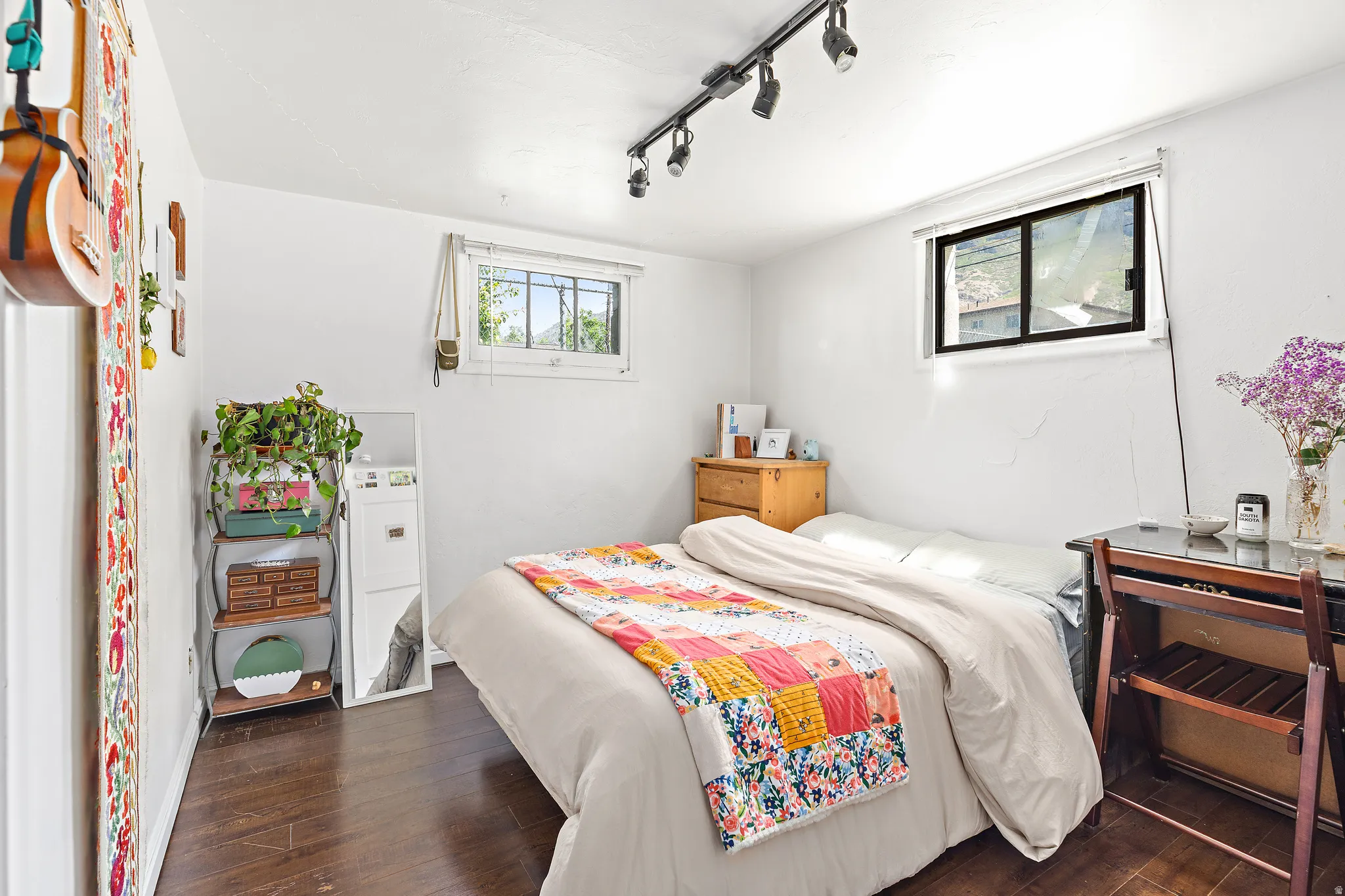 Interior room featuring wood-finish flooring, white walls, and two distinct windows